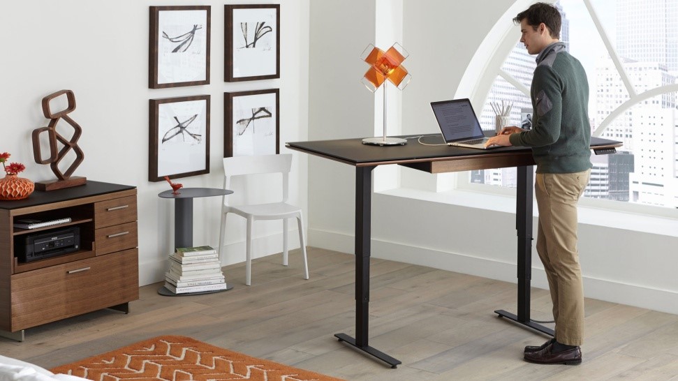 man at a standing desk in small office